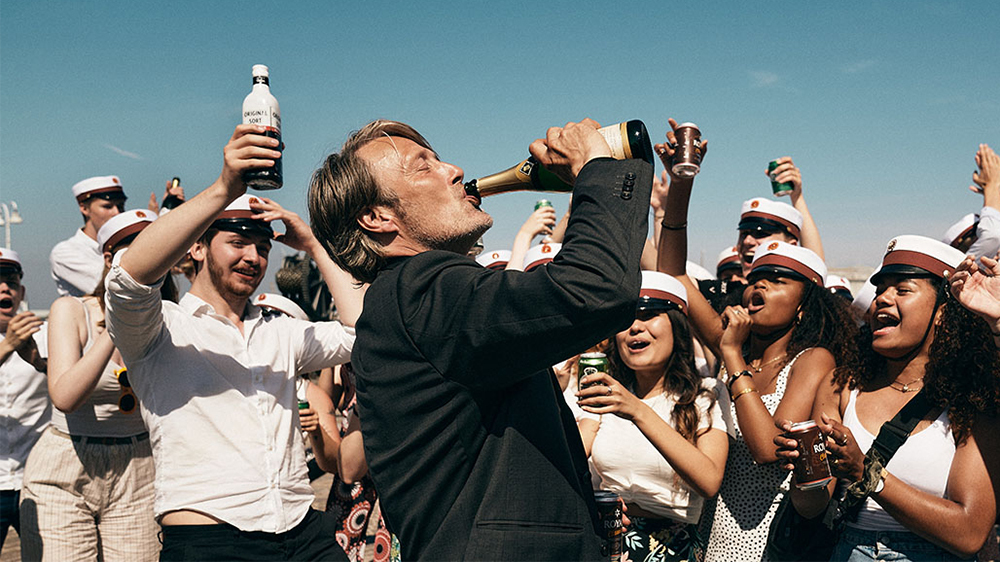 Mads Mikkelsen drinking from a bottle
